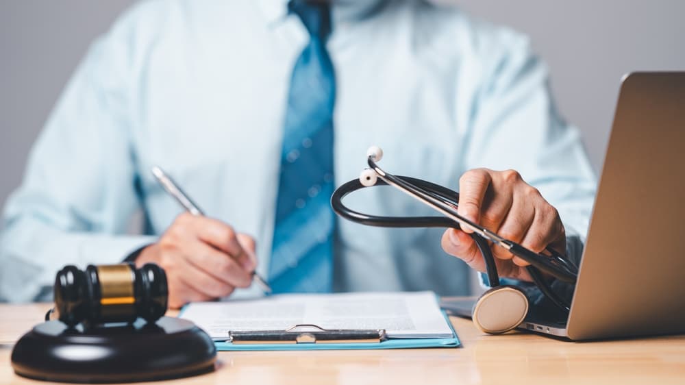 Professional in tie examines legal documents and medical evidence, symbolizing the intersection of law and healthcare in personal injury cases.