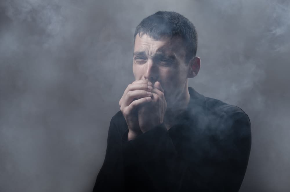 young man suffocating in the poisonous smoke