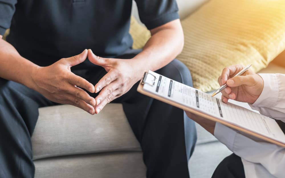 A man consults with a doctor or psychiatrist for diagnostic examination on men's health or mental illness in a medical clinic or hospital mental health service center.